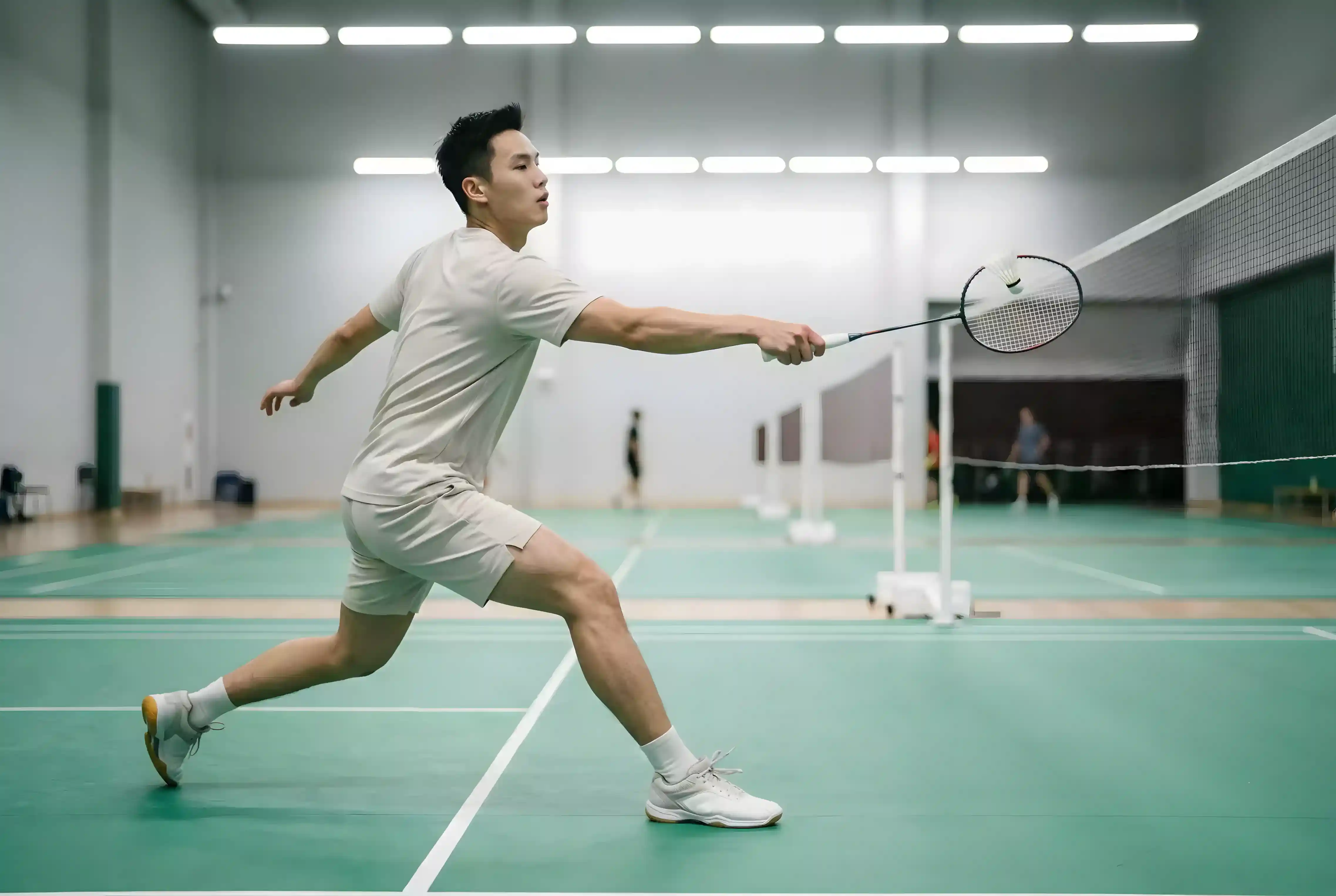 Badminton Einzel Wetten — Einzelspieler schlägt Federball im Sprung auf dem Court